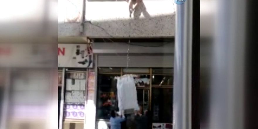 Çuvala doldurulan eşyaları balkondan iple taşıdılar