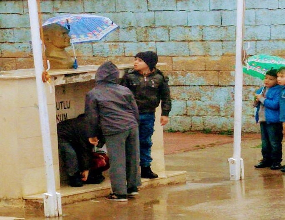 Minik öğrenciler Atatürk büstü ıslanmasın diye şemsiye tuttular